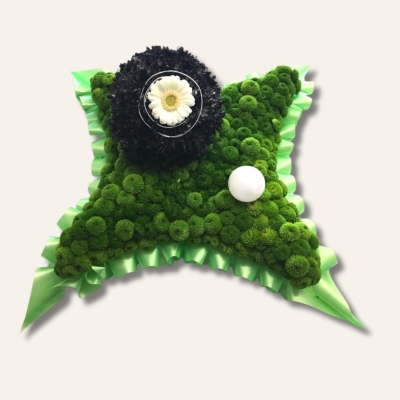 Bowls-themed funeral tribute with green chrysanthemum base, hand-sprayed black bowls ball, decorative wire, and floral accents.