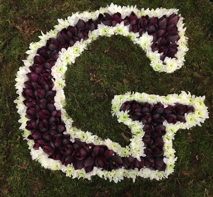 Letter-shaped funeral tribute on a 24