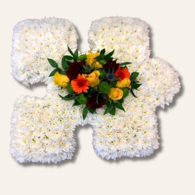 Puzzle piece funeral tribute with white chrysanthemum base and customisable focal flower.