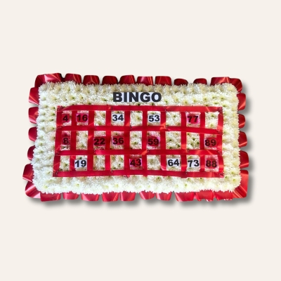 Bingo card funeral tribute with white chrysanthemum base, customisable ribbon edge, and personalised numbers