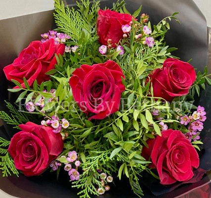 Bouquet featuring 6 luxury red roses with a filler florals, accented with diamanté in the roses, complemented by foliage, wrapped in luxury cellophane and matching gift bag, hand-tied in water.