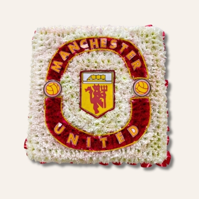 Manchester United badge-shaped funeral tribute made with white and yellow chrysanthemum, red carnations, and pipe cleaner with laminated detailing on a 24