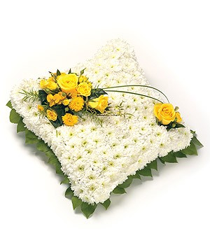 White chrysanthemum massed cushion funeral tribute with foliage edging and customisable ribbon and flower colours.