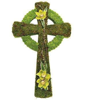 Celtic cross-shaped funeral tribute made with flat moss and green Kermit chrysanthemum, finished with a green floral focal and pearl detailing.