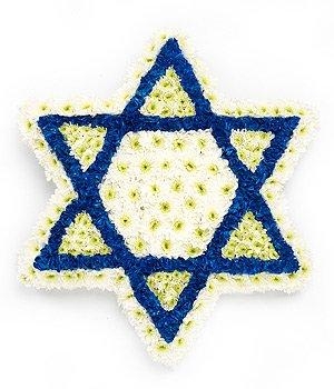 Star of David-shaped funeral tribute made with massed white chrysanthemum and blue spray paint detailing, measuring approximately 60cm.
