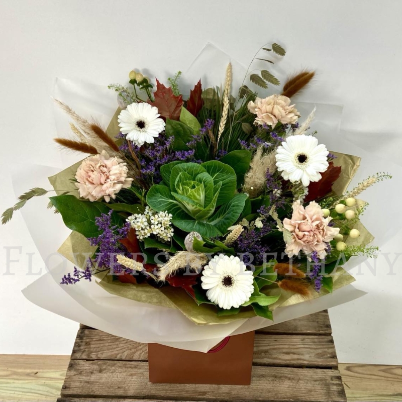 Woodland Whisper bouquet with white gerbera, blush carnations, berries and autumn grasses in natural gift wrap.