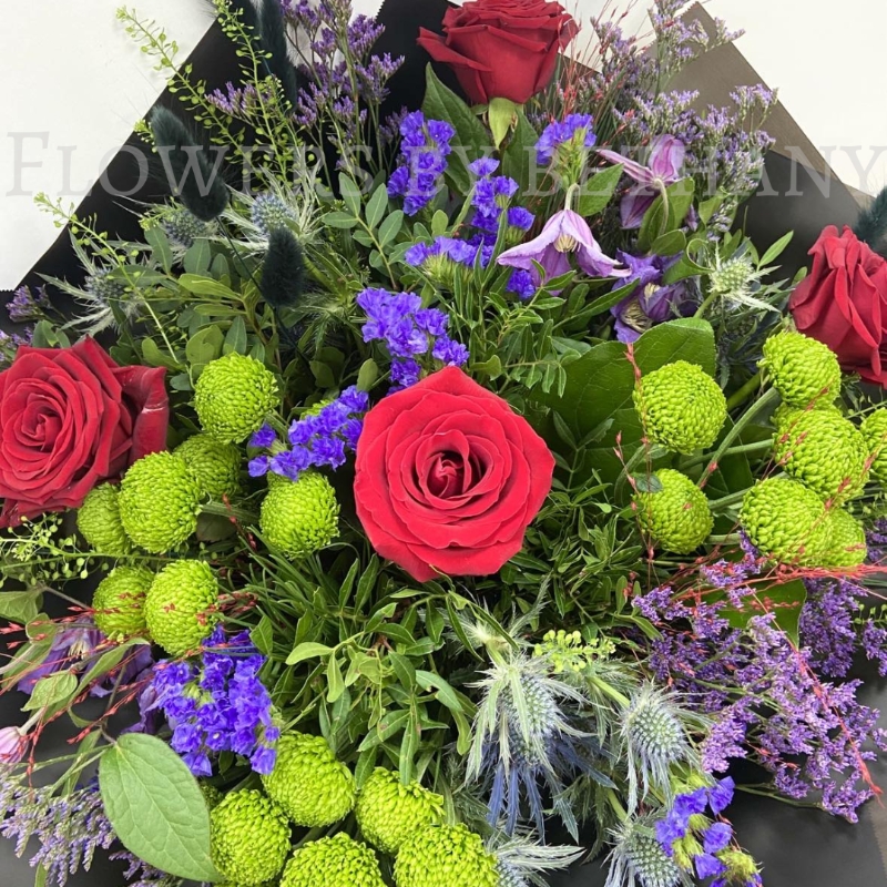 Elena bouquet with red roses, lime green blooms, purple flowers and thistle blue, hand-tied in black wrap.