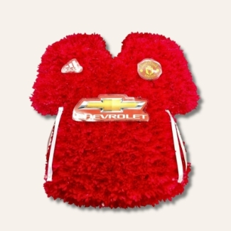 Manchester United shirt funeral tribute with fresh flower base, pipework detailing and printed waterproof badges, 21 x 21 inches, available in classic and modern shirt versions.