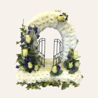 Gates of Heaven funeral tribute with white chrysanthemum base, deep blue focal and ivy edging, 20 x 18 inches, customisable focal flowers.