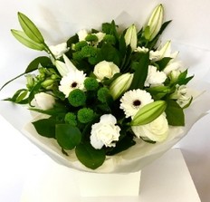 White and green hand-tied bouquet with lilies, roses, germini and green chrysanthemums presented in a gift bag.