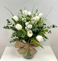 White Christmas vase arrangement with tulips, scented stocks, birch, mixed foliage and natural bow in a clear glass vase.