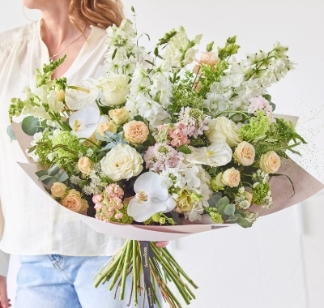 Luxury pastel hand tied bouquet with florist’s choice seasonal florals in soft neutral summer tones by Flowers by Bethany Leigh florist.