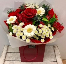 Red, white and blue Christmas bouquet with glittered red roses and mixed seasonal florals, presented in luxury gift wrap.