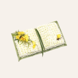 Open Prayer Book funeral tribute with white chrysanthemum base, yellow floral focal and foliage, 31 x 61 cm, customisable ribbon and flowers.