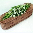 White oriental lily casket spray with complementary foliage.