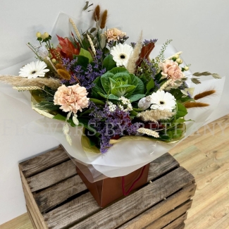 Woodland Whisper bouquet with white gerbera, blush carnations, berries and autumn grasses in natural gift wrap.