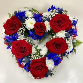 Mixed floral funeral heart tribute in red, white, and blue with luxury flowers representing British colours.