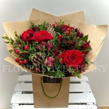 Ruby red seasonal bouquet with festive tones, rustic kraft wrap and signature gift bag.