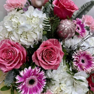 Pink Christmas bouquet with snowy glitter roses, white hydrangea, silver birch, seasonal pink florals and pink baubles, wrapped in iridescent cellophane.